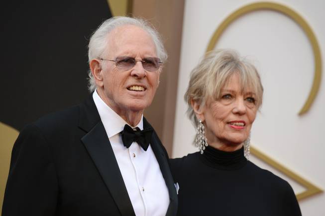 Bruce Dern, left, and Andrea Beckett arrive at the Oscars on Sunday, March 2, 2014, at the Dolby Theatre in Los Angeles.  (Photo by Jordan Strauss/Invision/AP)